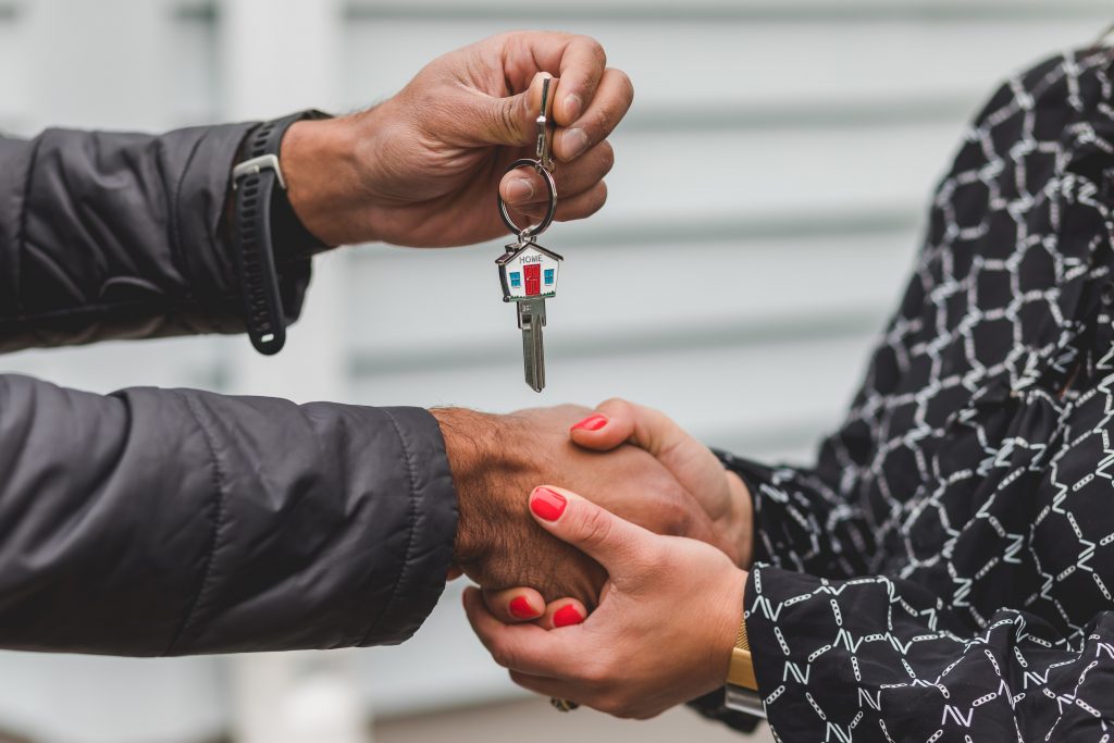 Real estate agent handing over keys to house